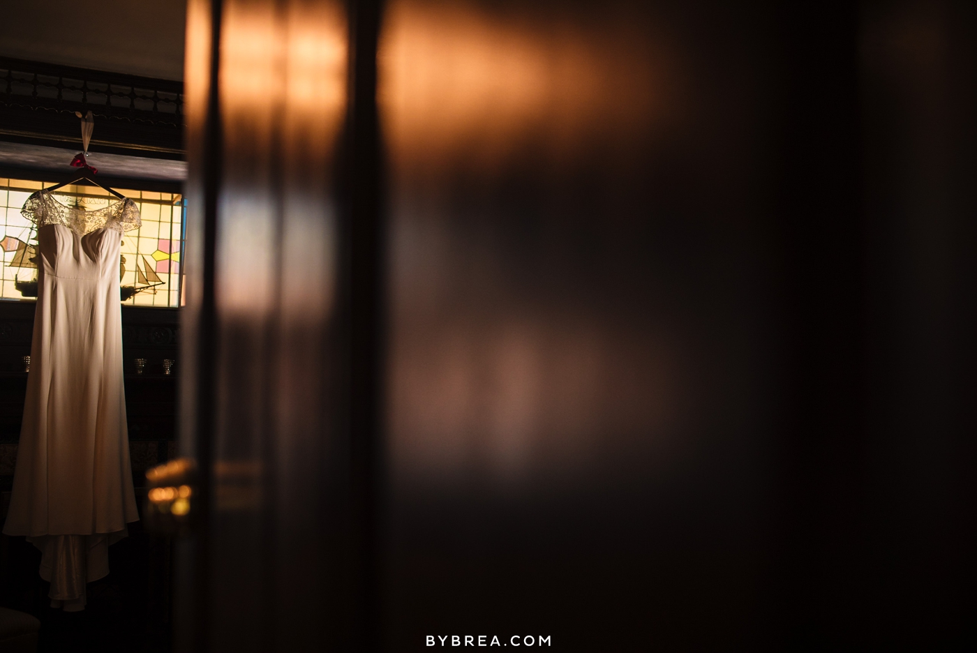 Vandiver Inn wedding Jenny Yoo gown hangs from stained glass window