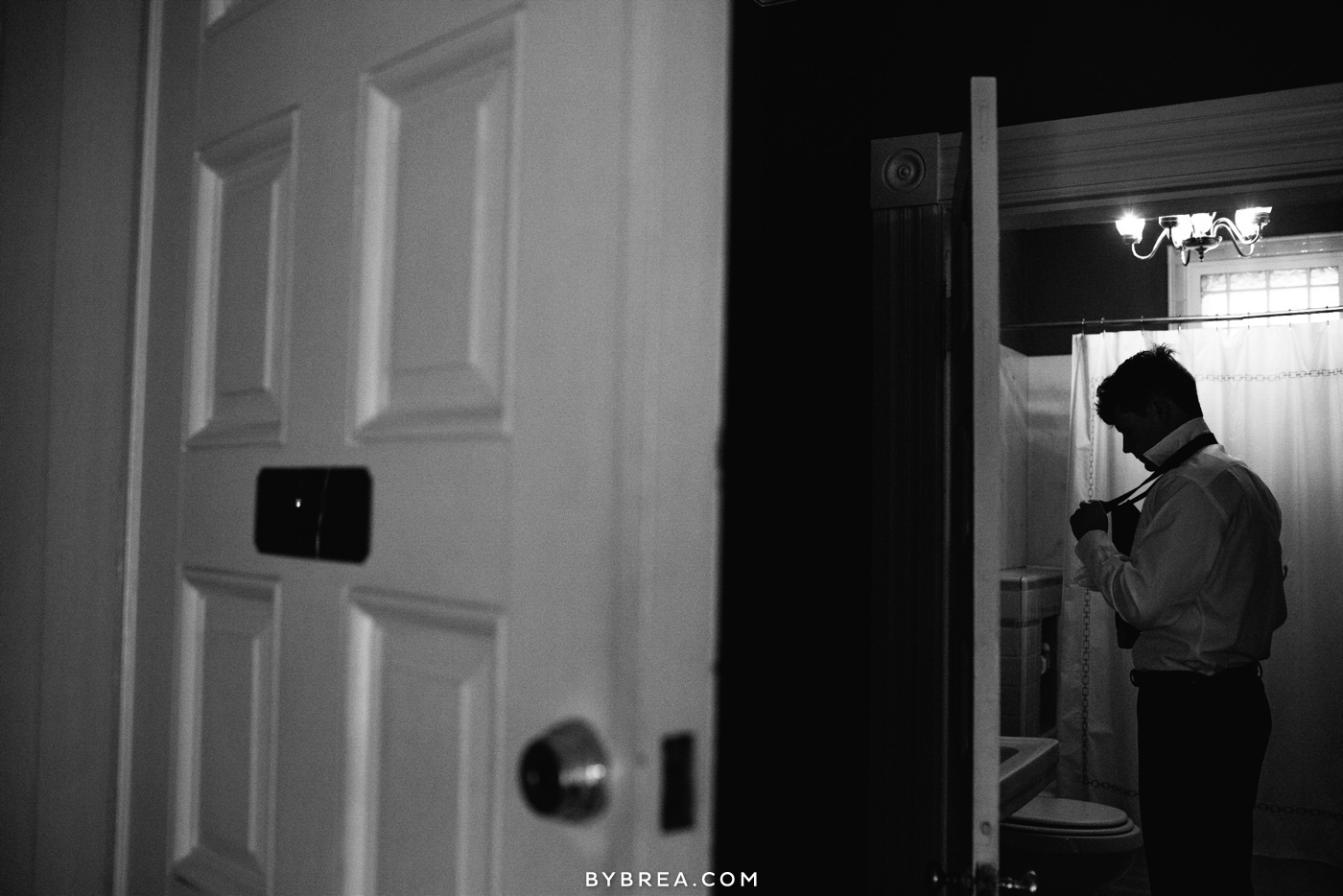 Vandiver Inn wedding groom looking down while knotting tie