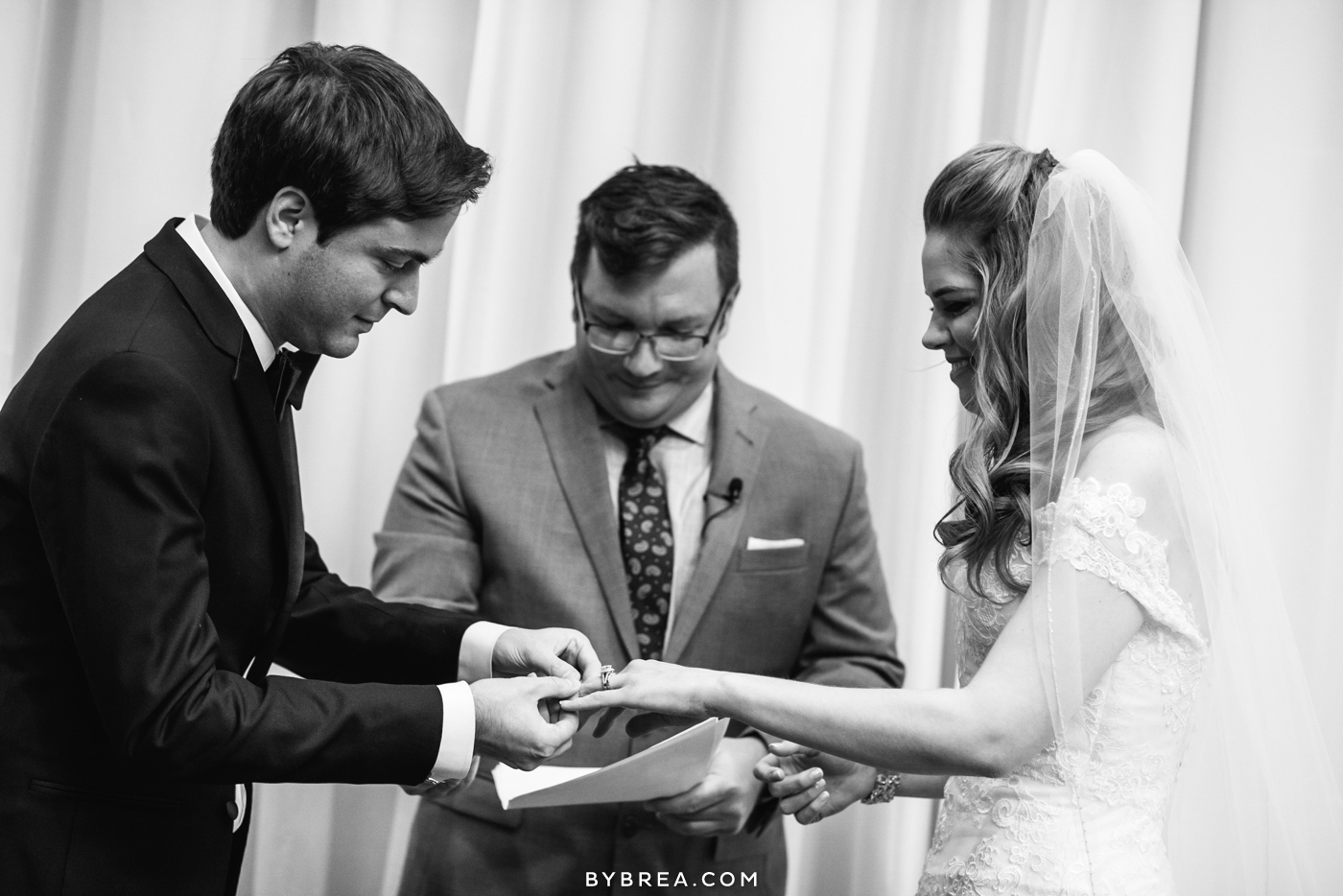 Hotel at Arundel Preserve wedding photo ceremony groom puts ring on bride