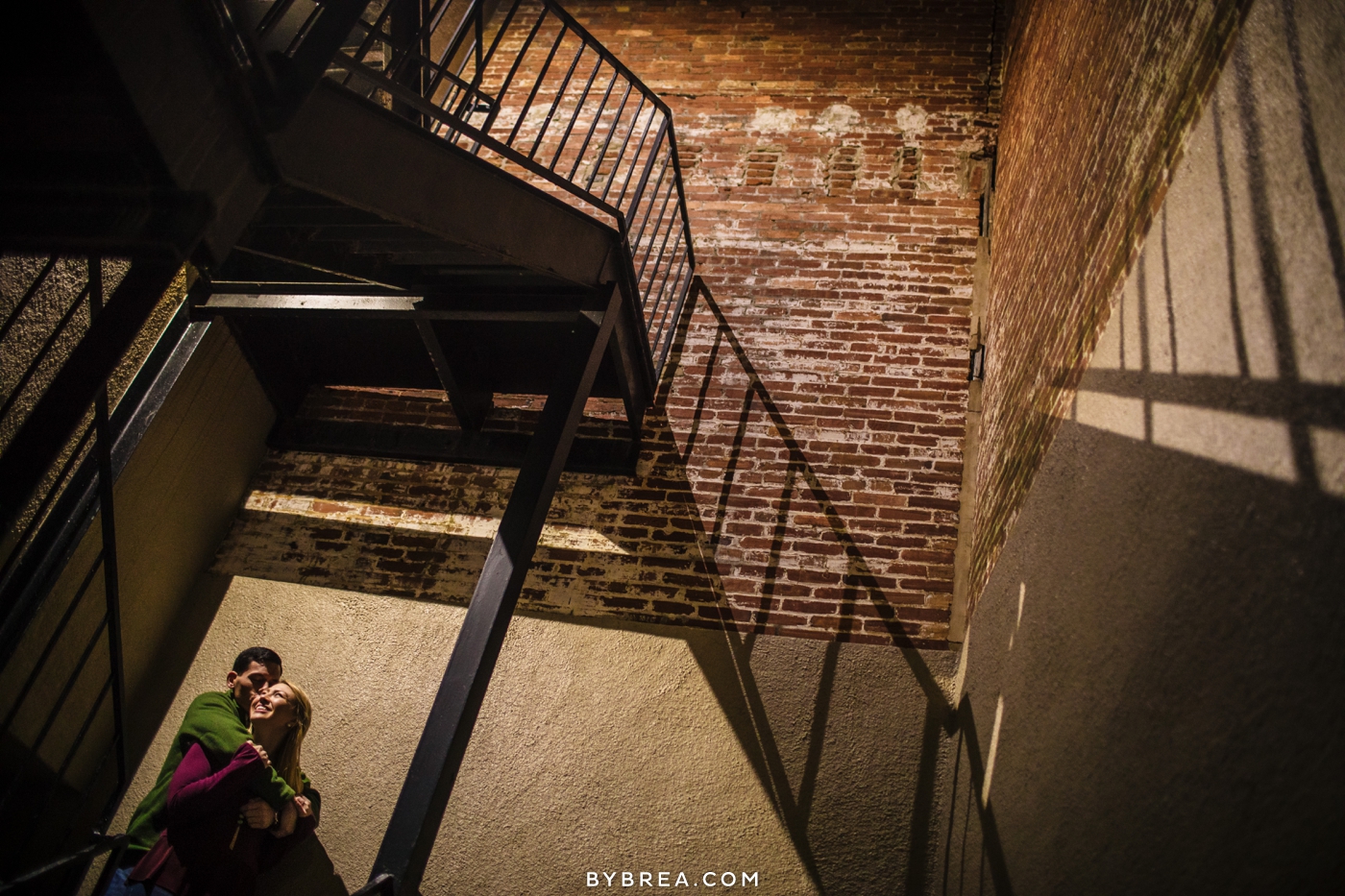 Baltimore engagement session photo couple under stairs exposed brick