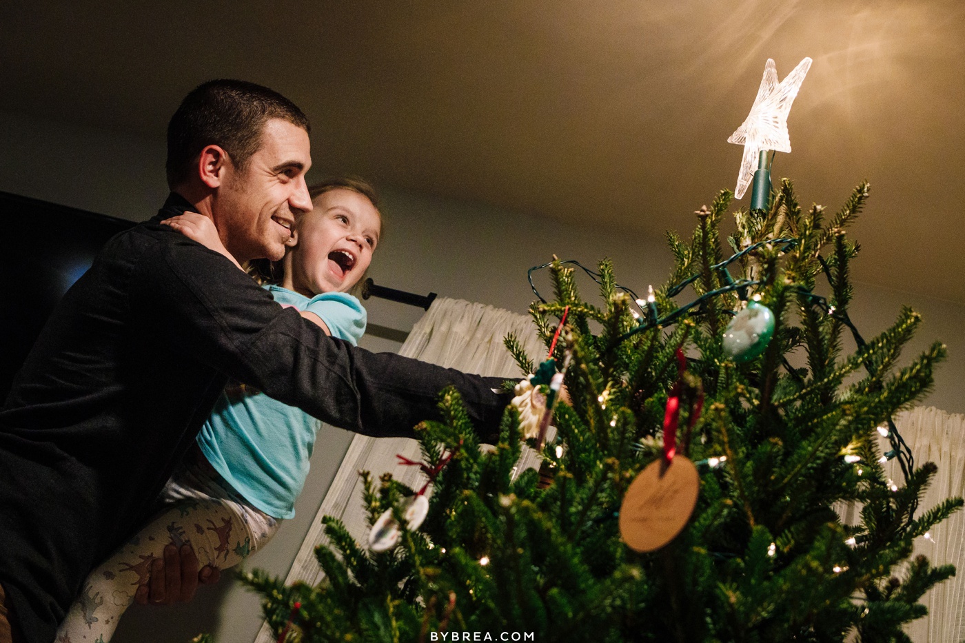 day in the life session of dad and daughter decorating the christmas tree