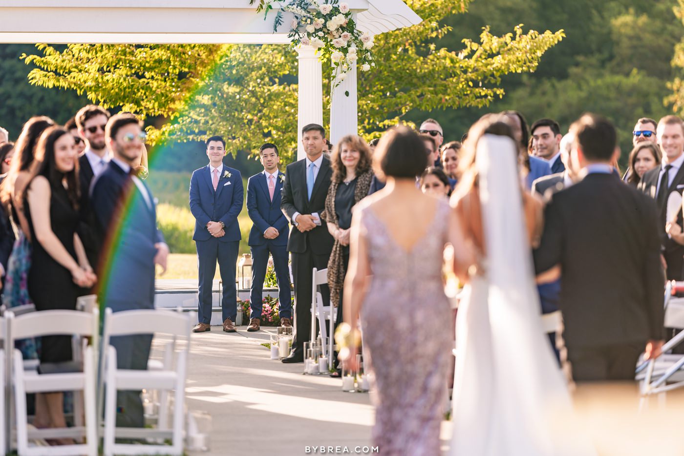 groom watches bride walk down the aisle at springfield manor with rainbow