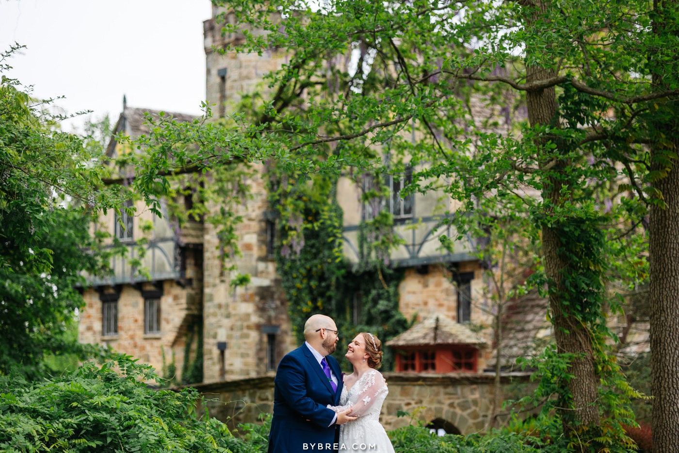 Bride and groom with gorgeous cloisters castle in background